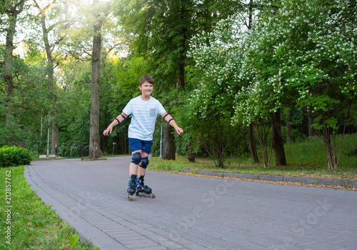 A teenager boy is rollerblading in the park.