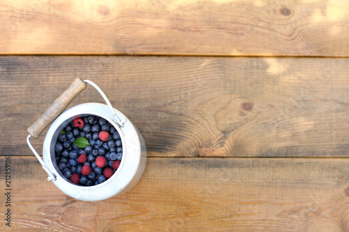 summer harvest of wild berries/ jar with blueberries and raspberries on a wooden table top view