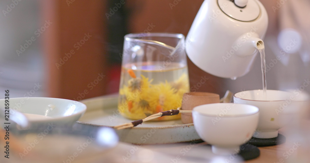 Pouring tea to a cup in restaurant Pouring tea to a cup in restaurant