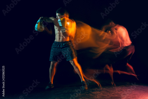 Male boxer boxing in a dark studio