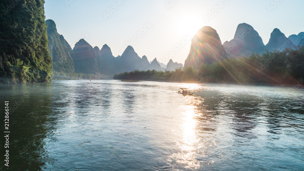 bamboo boat moving at Li River during sunset time - obrazy, fototapety, plakaty 