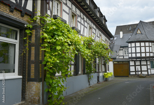 Fototapeta Naklejka Na Ścianę i Meble -  old small German town on the river bank narrow streets, pavement flowers on the windows
