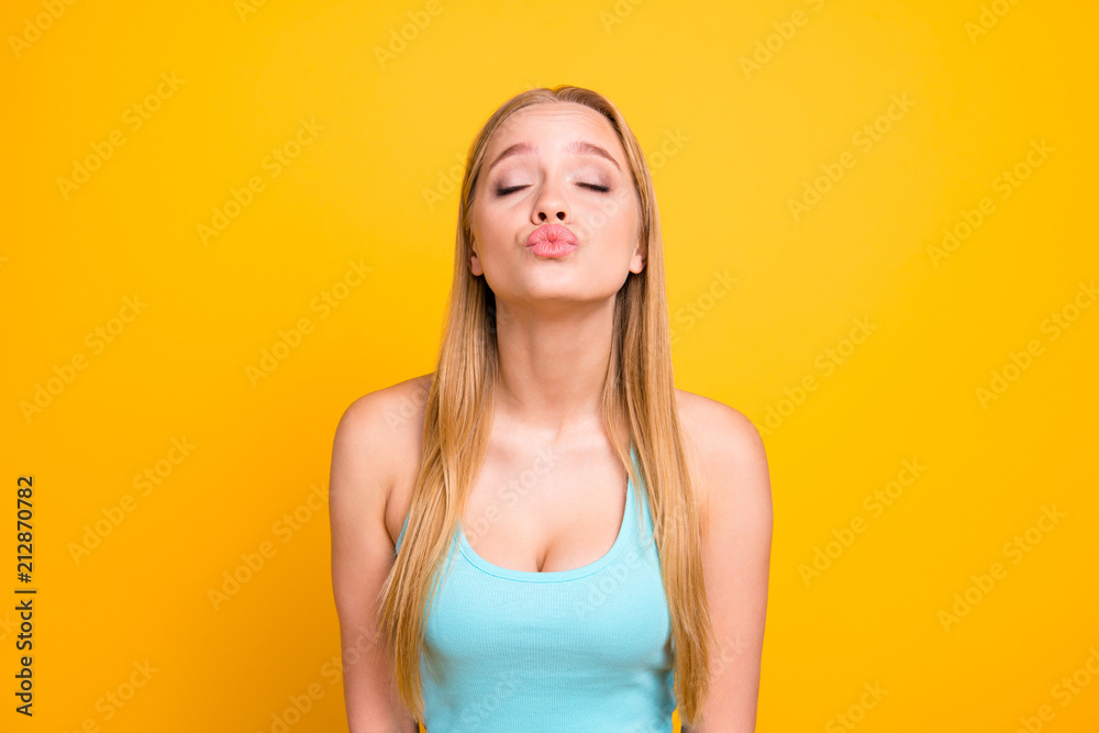 Very beautiful and gentle blonde girl with long straight hair closed her eyes in anticipation of a kiss isolated on yellow background Very beautiful and gentle blonde girl with long straight hair closed her eyes in anticipation of a kiss isolated on yellow background
