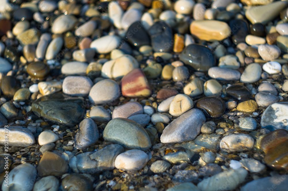 pebble stones on the sea beach, the rolling waves of the sea with foam
