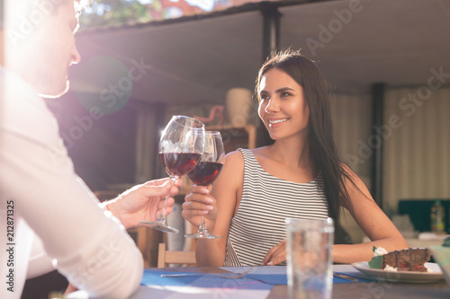 Romantic date. Beautiful stylish woman smiling broadly while having romantic date with her caring husband