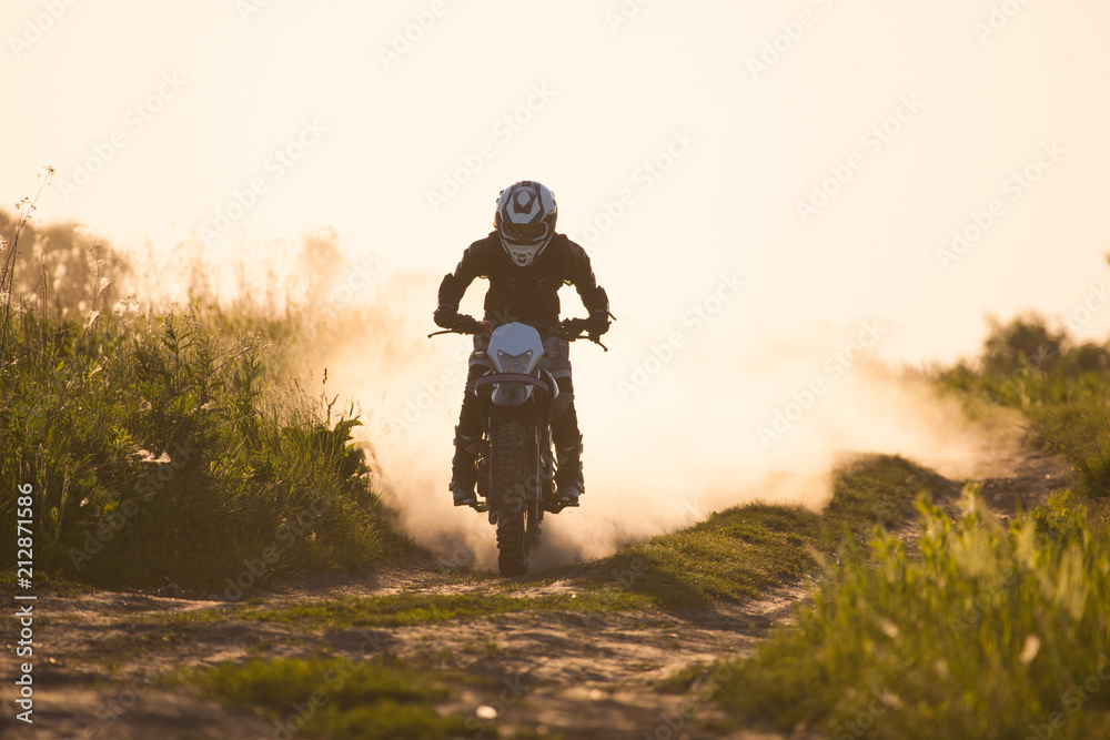 photo of a motorcyclist at sunset riding speed along the road photo of a motorcyclist at sunset riding speed along the road