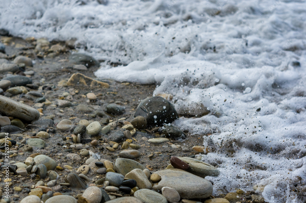 pebble stones on the sea beach, the rolling waves of the sea with foam pebble stones on the sea beach, the rolling waves of the sea with foam
