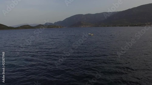 Aerial shot over the sea. Fishing boat in the horizon. Travel across islands. photo