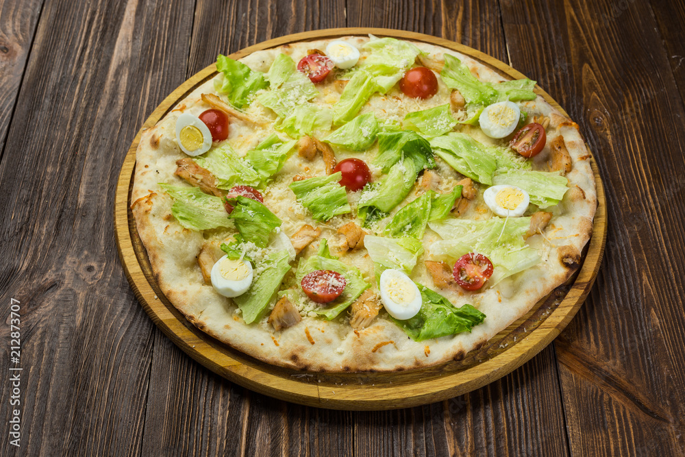 Pizza Caesar with chicken and tomatoes on wooden background Pizza Caesar with chicken and tomatoes on wooden background