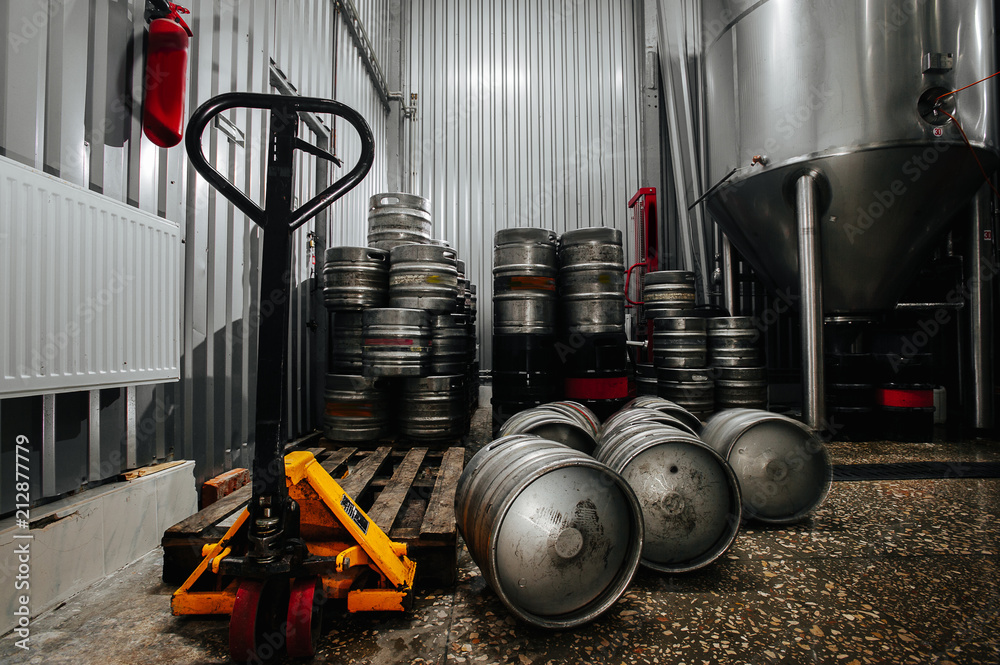 Many metal beer keg stand in a warehouse of brewery. Time to delivery