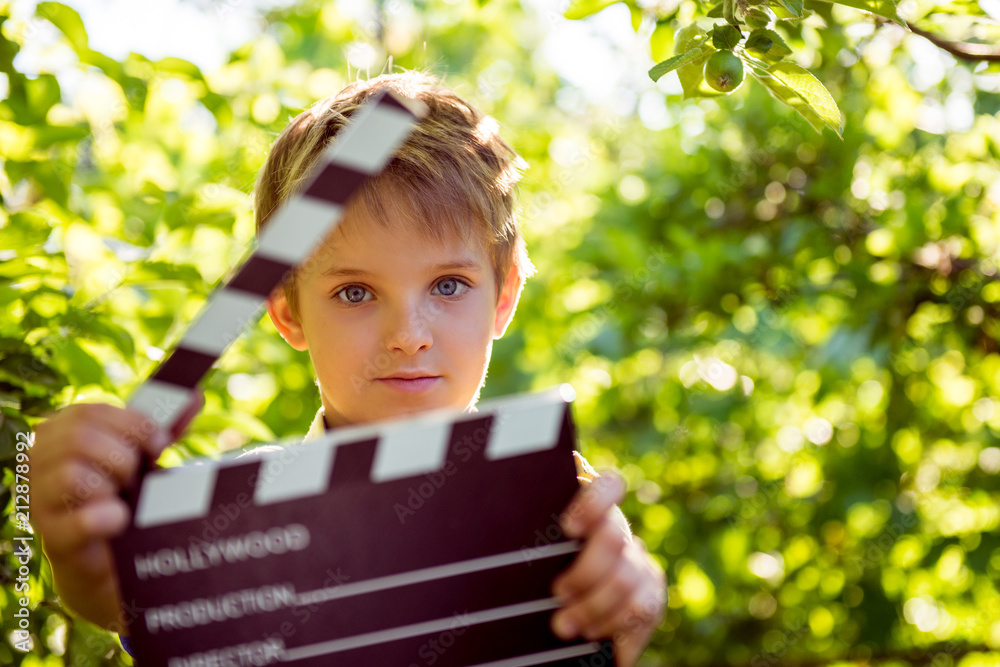 Naklejka premium Film is shot, Filming of children's film, Cartoons for children. Take pictures of children's portraits. Casting children for a role in the cinema. Boy with a cracker 