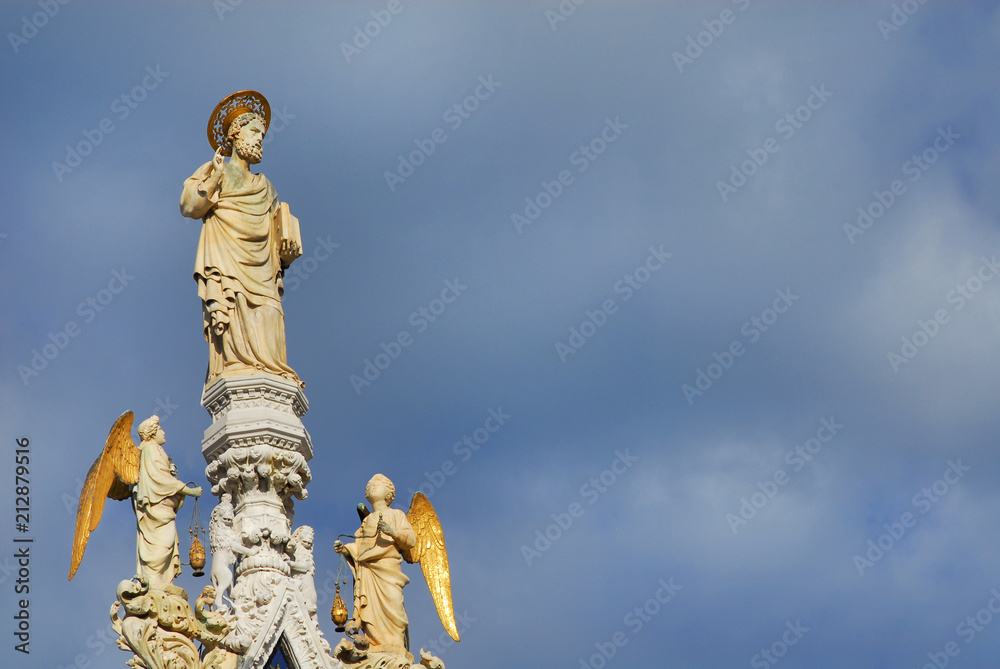 Fototapeta premium Saint Mark blessing medieval statue with angels at the top of Venice Cathedral, 15th century (with clouds and copy space)