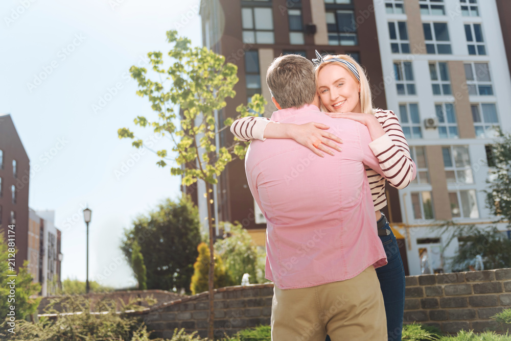 True love. Delighted nice woman hugging her husband while expressing her feeling to him True love. Delighted nice woman hugging her husband while expressing her feeling to him