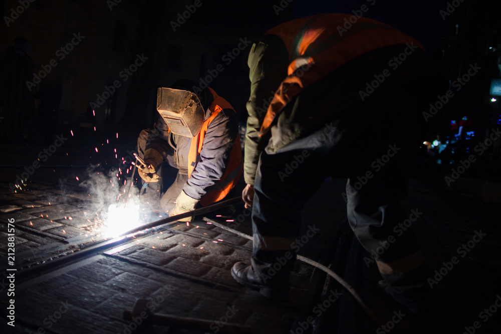 photo of workers who perform work on welding metal and repair