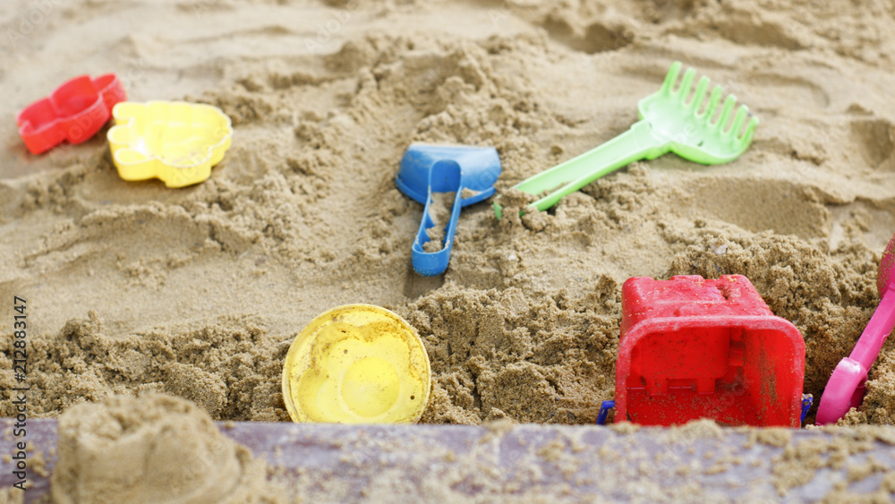 children's toys are scattered in the sandbox. Blade, rake, pail for building a sand tower children's toys are scattered in the sandbox. Blade, rake, pail for building a sand tower