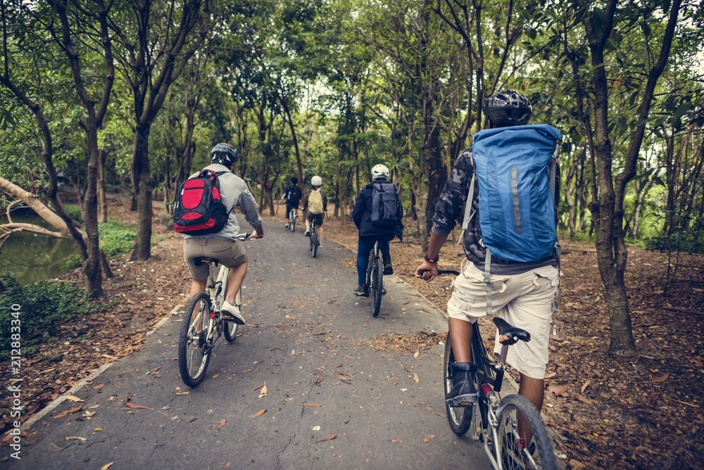 Group of friends ride mountain bike in the forest together