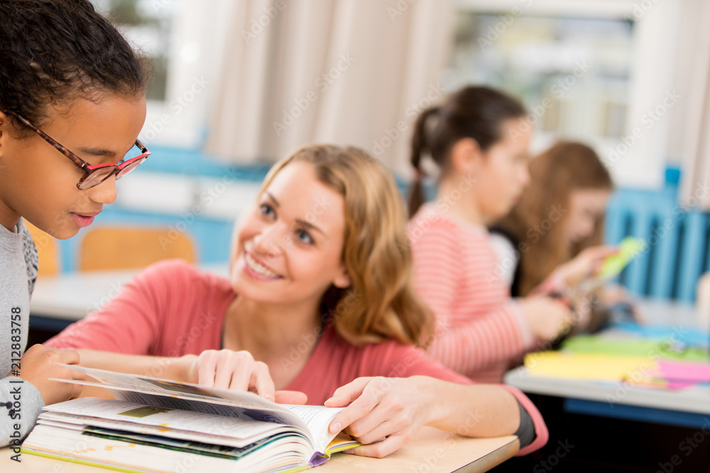 teacher helping schoolgirl at school teacher helping schoolgirl at school