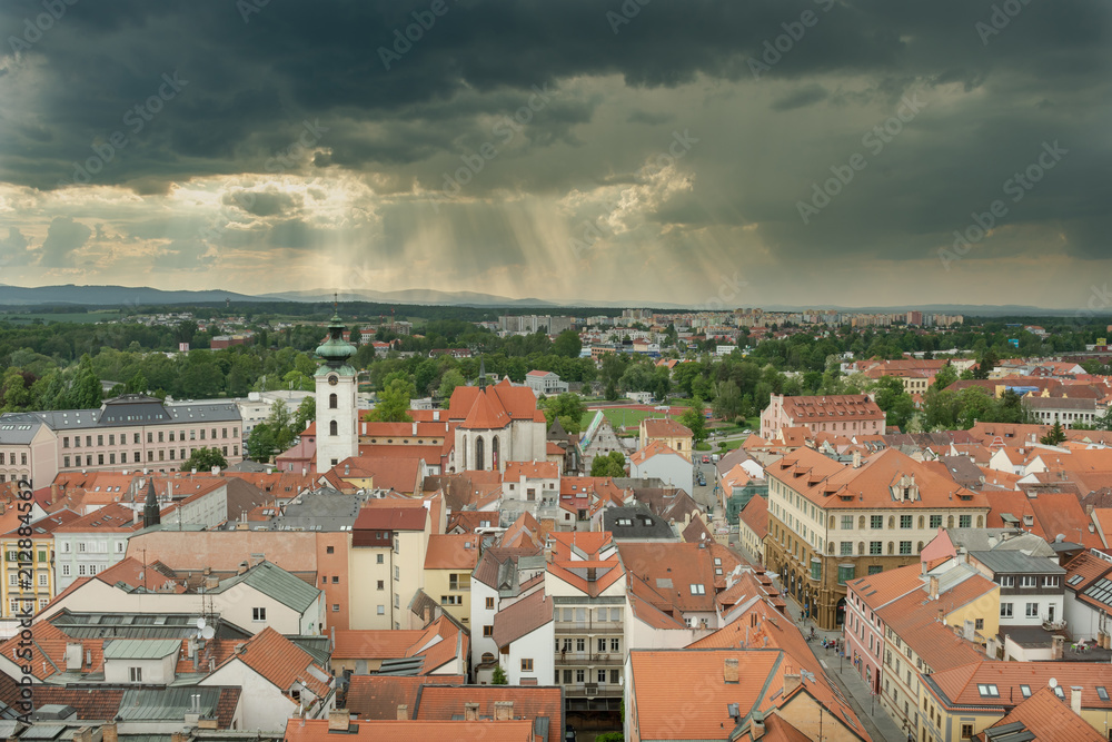 view over the roof tops of northern Budweis and the dominican monastery under a dark cloudy sky