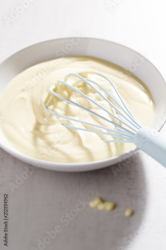 Bowl of vanilla custard with blue whisk 