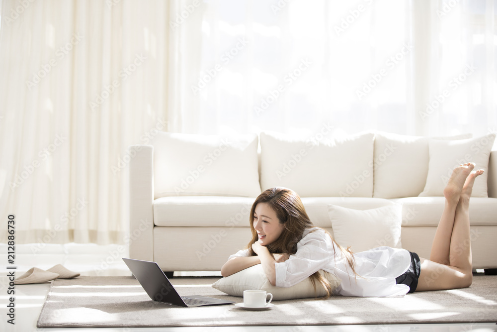 Cheerful young Chinese woman using laptop at home Cheerful young Chinese woman using laptop at home