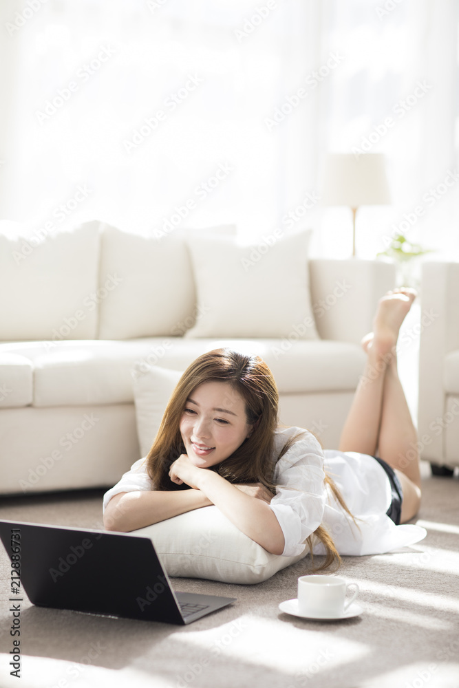 Cheerful young Chinese woman using laptop at home Cheerful young Chinese woman using laptop at home