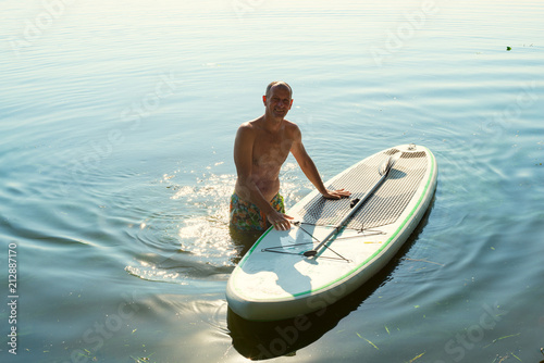 Obraz na płótnie Joyful man is relaxing on a SUP board and having fun w salonie