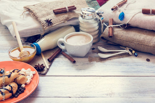 Breakfast of coffee, croissants, milk, honey, sugar, cinnamon, anise