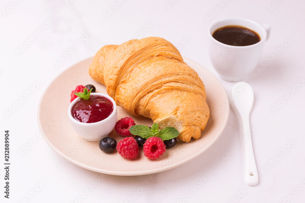 Coffee, fresh croissant with jam and berries for breakfast Coffee, fresh croissant with jam and berries for breakfast