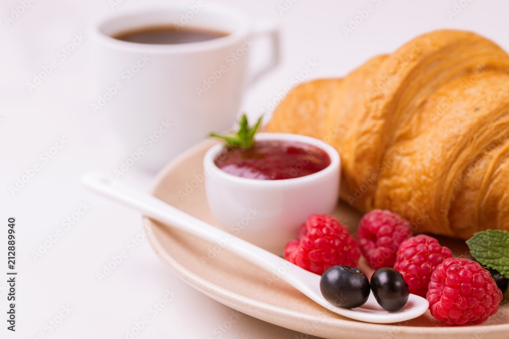 Coffee, fresh croissant with jam and berries for breakfast Coffee, fresh croissant with jam and berries for breakfast