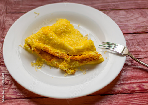 Omelette with grated cheese on a plate.