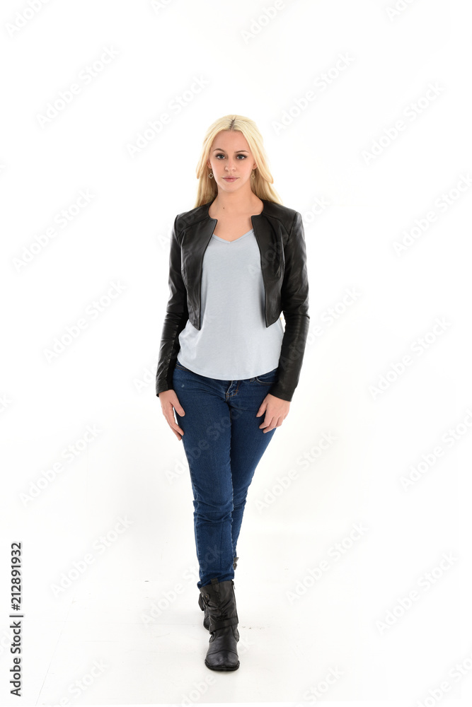 full length portrait of blonde girl wearing casual blue shirt and leather jacket. standing pose, isolated on white studio background. full length portrait of blonde girl wearing casual blue shirt and leather jacket. standing pose, isolated on white studio background.