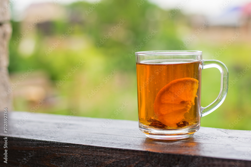 Tea mug with lemon on wooden rails on a summer day Tea mug with lemon on wooden rails on a summer day