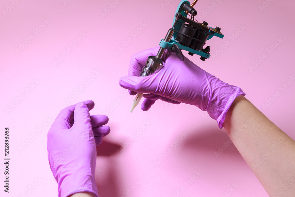 Female Hands In Pink Rubber Gloves Hold A Blue Tattoo Machine On A Pink  Background Stock Photo Picture And Royalty Free Image Image 105104396