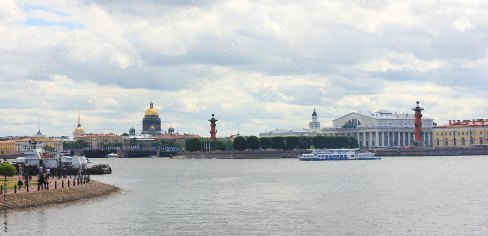 St. Petersburg City Skyline with Neva River, Saint Isaac's Cathedral, Rostral Columns, Palace Bridge in Russia. Scenic Cityscape on Gloomy Cloudy Summer Day and Tourists on Embankment Water Front.