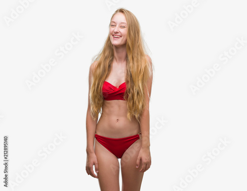 Blonde teenager woman wearing red bikini winking looking at the camera with  sexy expression, cheerful and happy face. Stock Photo | Adobe Stock
