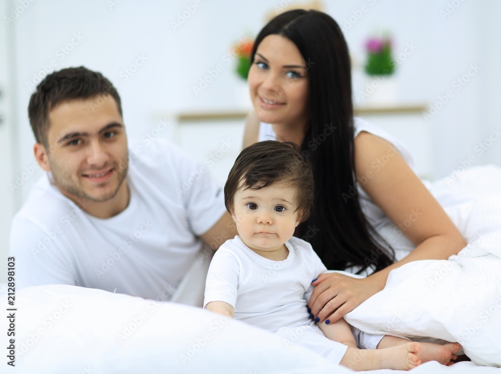 Cheerful family having fun together lying on a bed