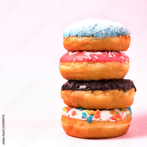 Delicious donuts for birthday on pastel pink background.