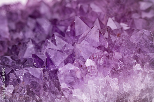Close up purple shining amethyst quartz crystal texture abstract background