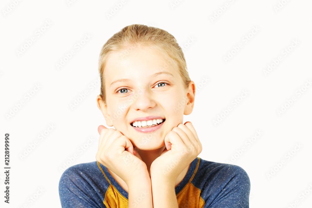 Young beautiful teenage girl with blond hair in ponytail wearing yellow baseball t-shirt with blue sleeves. Pretty female smiling, hands on chin, standing on isolated white background with copy space. Young beautiful teenage girl with blond hair in ponytail wearing yellow baseball t-shirt with blue sleeves. Pretty female smiling, hands on chin, standing on isolated white background with copy space.