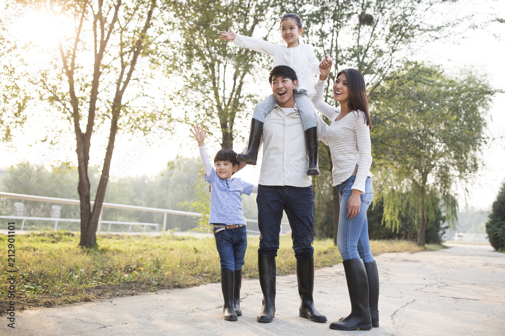 Cheerful young Chinese family playing outdoors Cheerful young Chinese family playing outdoors