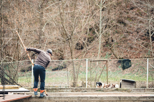 mountain trout grower stands near the fishpond with the net in his hands photo