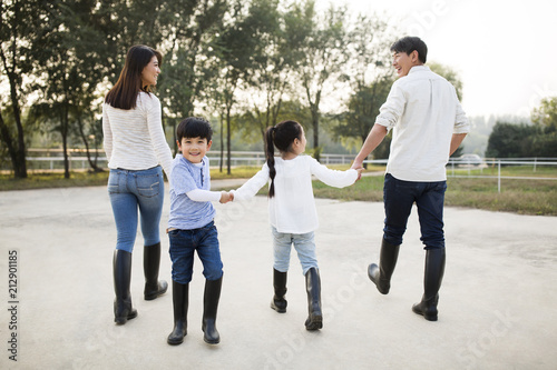 Young Chinese family holding hands walking photo