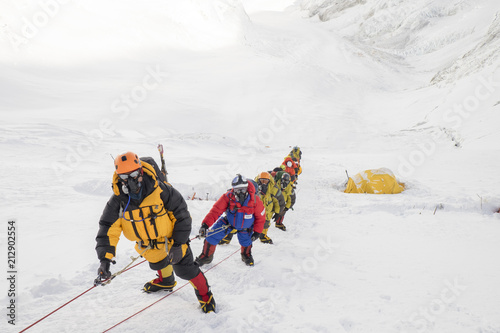 Roped team of mountaineers wearing oxygen masks