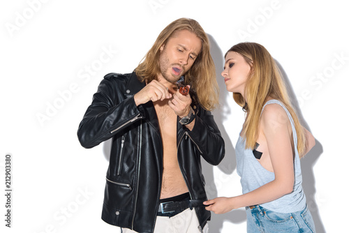 young addicted couple with pipe smoking cannabis on white