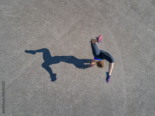 Aerial view of sportive young woman training handstand