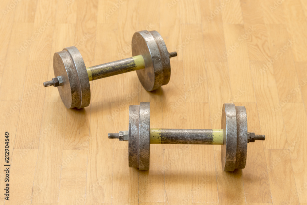 Two iron dumbbells on the floor. the concept of a healthy lifestyle and sport. Two iron dumbbells on the floor. the concept of a healthy lifestyle and sport.