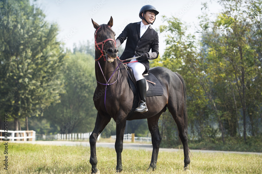 Cheerful young Chinese man riding horse Cheerful young Chinese man riding horse