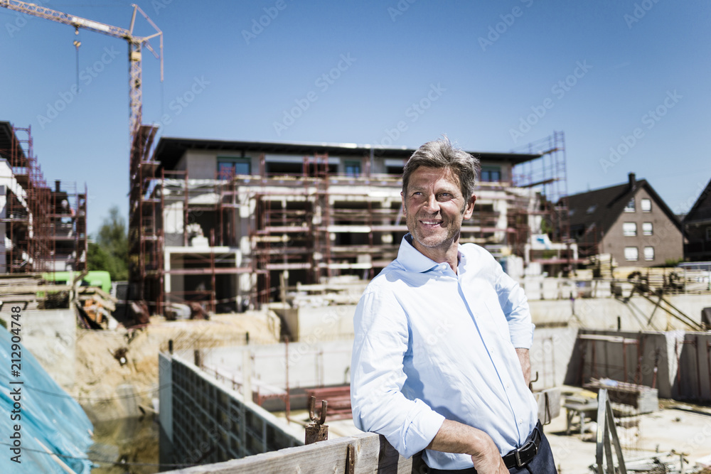 Smiling man on construction site looking around Smiling man on construction site looking around