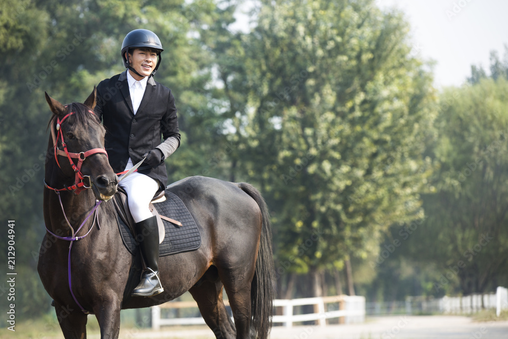 Young Chinese man riding horse 