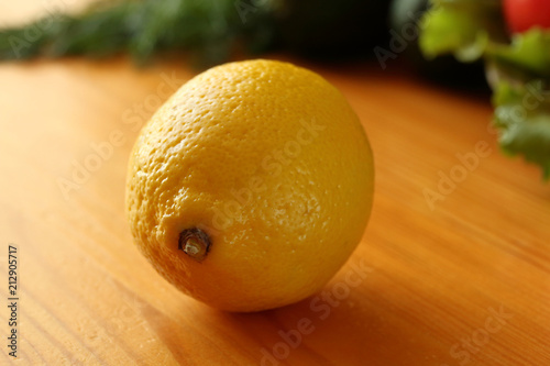 Single fresh ripe lemon on a wooden table in the kitchen